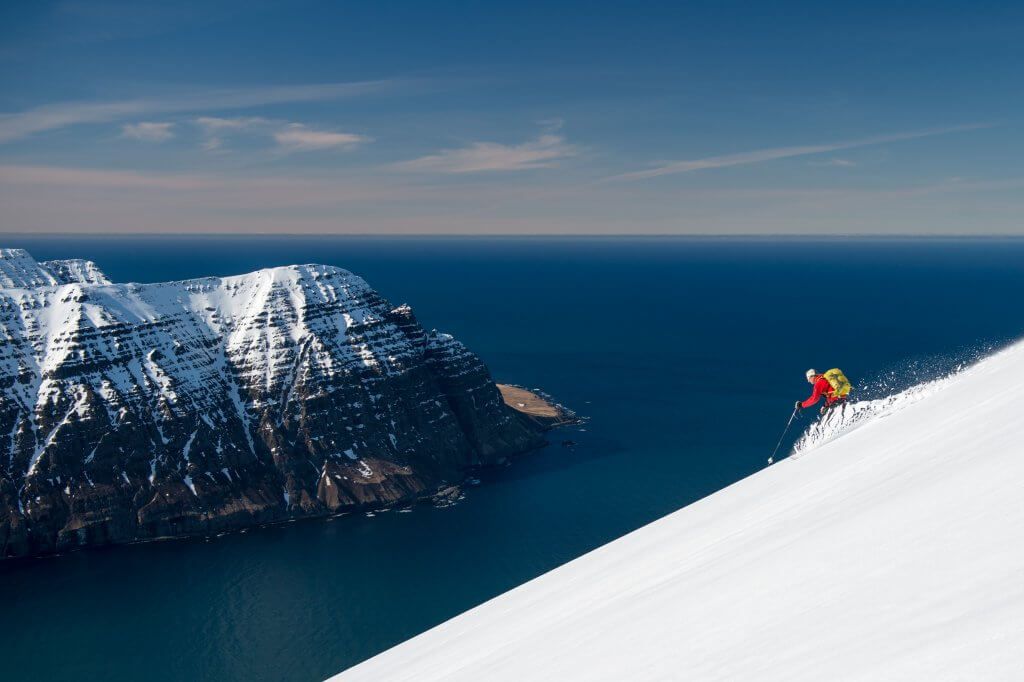 Man heli-skiing towards an icy lake in Northern Iceland on luxury heli-skiing vacation