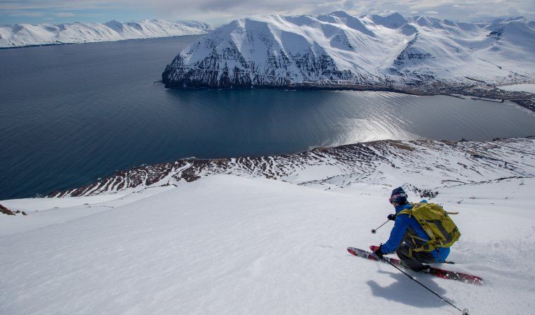 Man heli-skiing towards an icy lake in Northern Iceland on luxury heli-skiing vacation