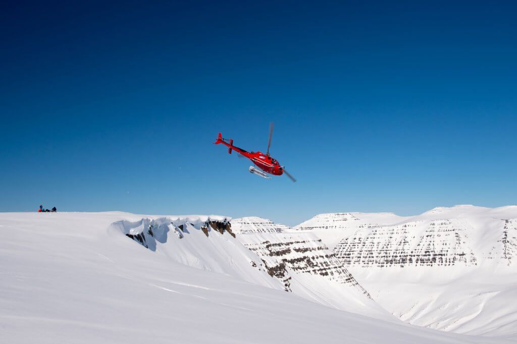 Helicopter flying over Iceland's Arctic landscapes during heli-ski tour