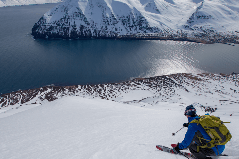 Man heli-skiing towards an icy lake in Northern Iceland on luxury heli-skiing vacation