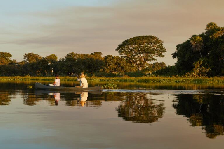 Two people canoeing down the river on a wildlife excursion in the Pantanal