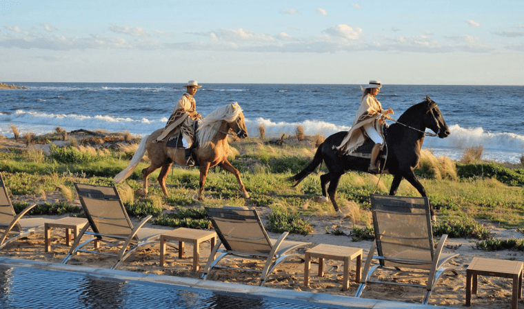 Two travelers horseback riding in Jose Ignacio along the coast