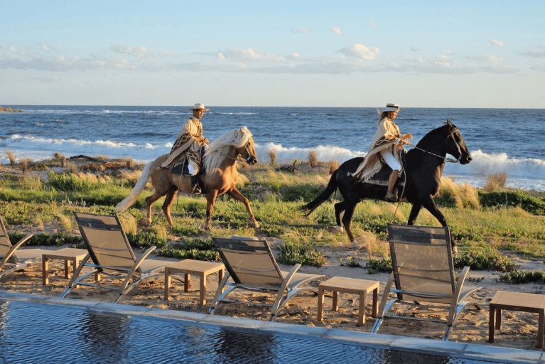 Two travelers horseback riding in Jose Ignacio along the coast