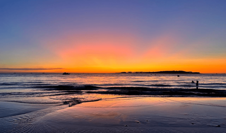 Striking orange sunset over the ocean at Playa La Mansa in Punta del Este