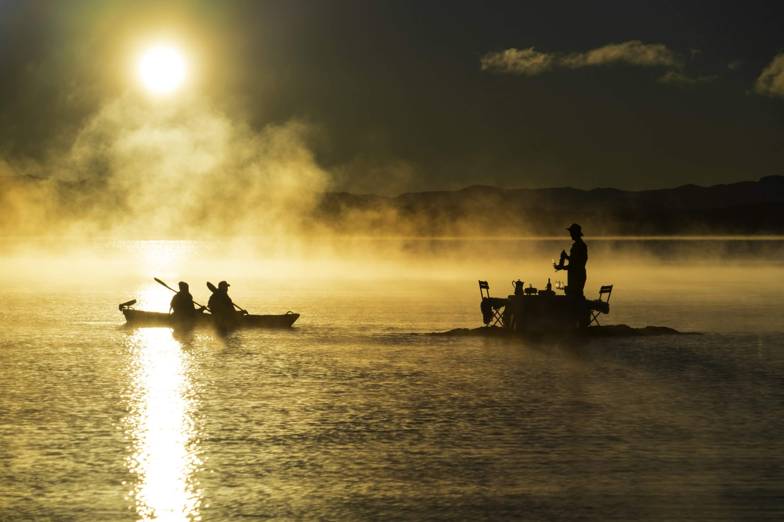 Couple kayaking to a private picnic in the middle of a lake in Bariloche in Argentina
