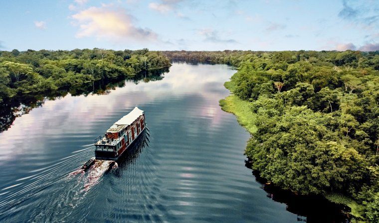 Aerial view of the Aria boat cruising down the Peruvian Amazon