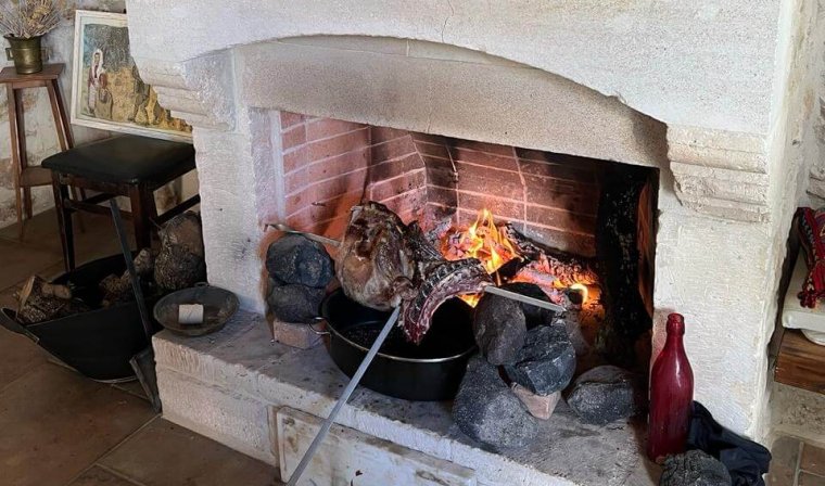 Local family cooking lamb BBQ for traveler in private home in Crete