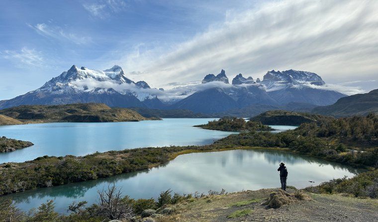 Woman taking picture of stunning lakes during hiking tour in Patagonia
