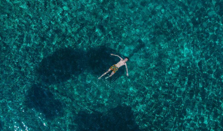 Aerial of man snorkeling in turquoise waters in Croatia