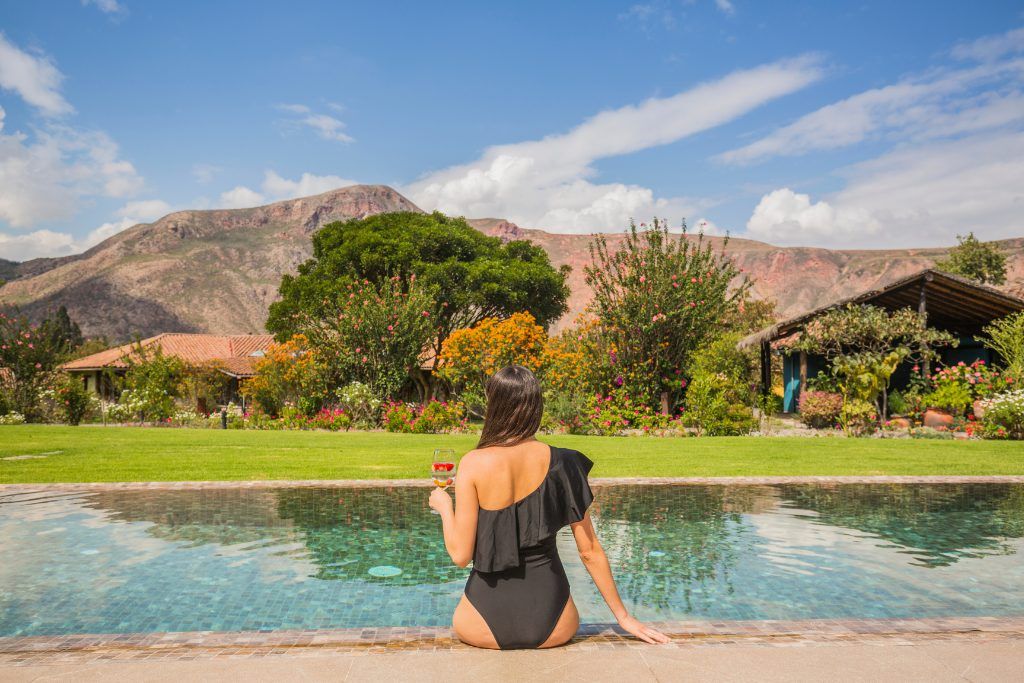 Woman enjoying views of the Sacred Valley from the pool at Hotel Sol Y Luna in Peru