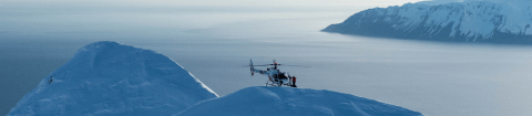 View of a private helicopter on Iceland's snowy mountains and inlets during luxury Polar tour