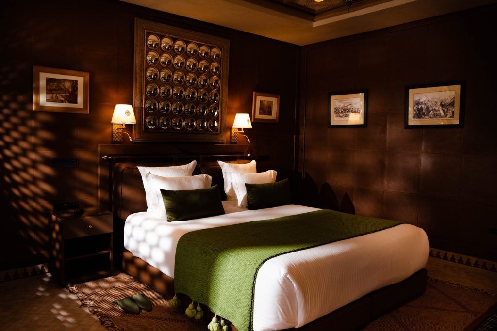 A bedroom with dark green accents and brown walls at Olinto.