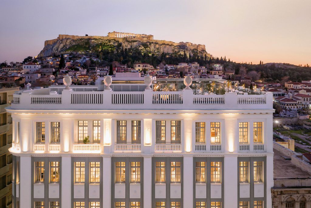 The exterior of The Dolli Hotel in Athens, with the Acropolis in the background.