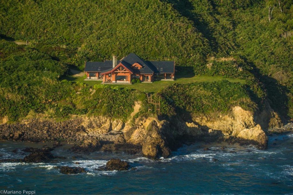 A view of the Mari Mari lodge sitting atop a cliff overlooking the ocean in Chilean Patagonia.