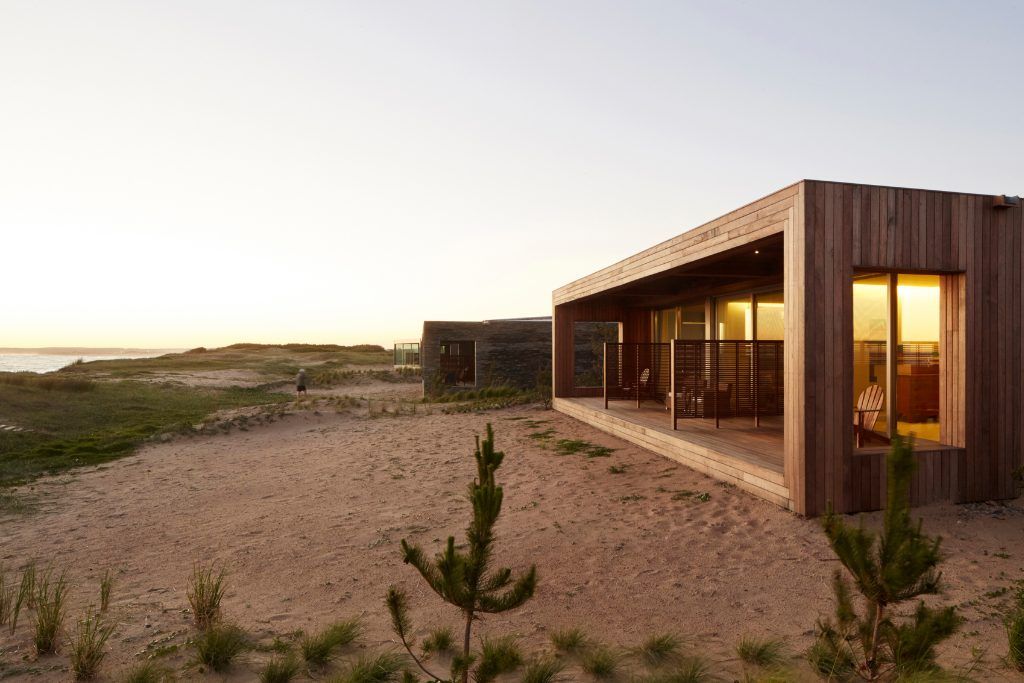 The exterior of Bahia Vik with a clear sandy area in front of the property.