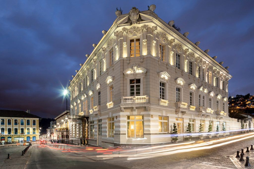 The exterior of Casa Gangotena at night with the windows lit up.