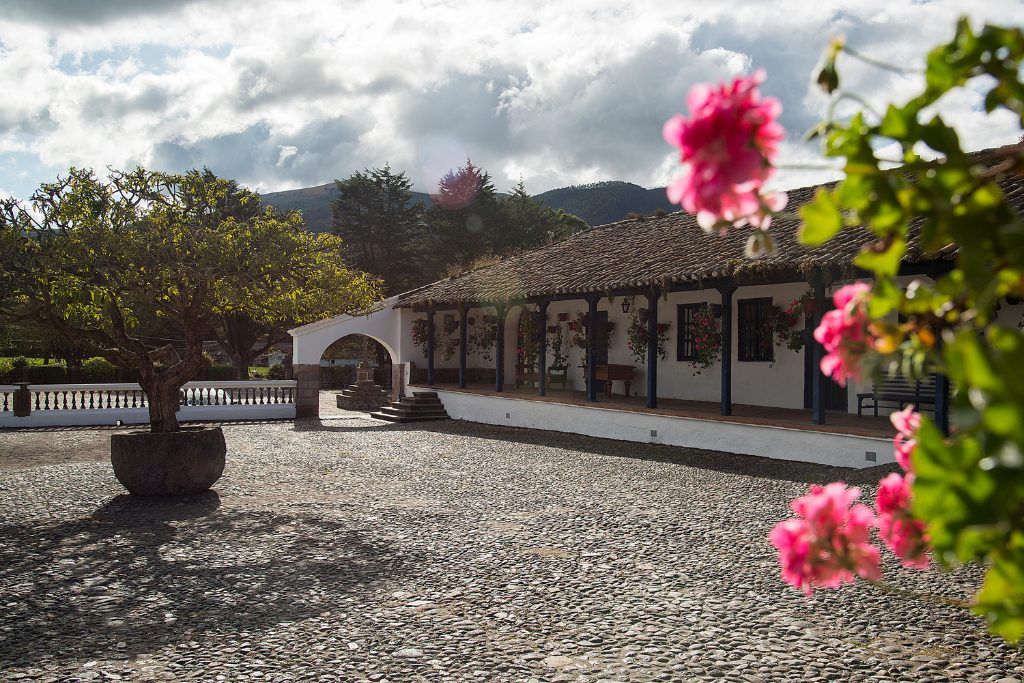 The exterior of Hacienda Zuleta with flowers in the foreground.