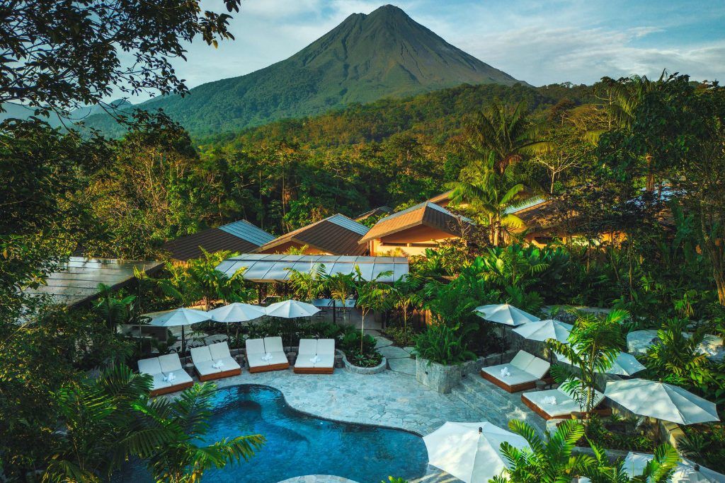 An aerial view of the swimming pool at Nayara Gardens with the volcano in the background.