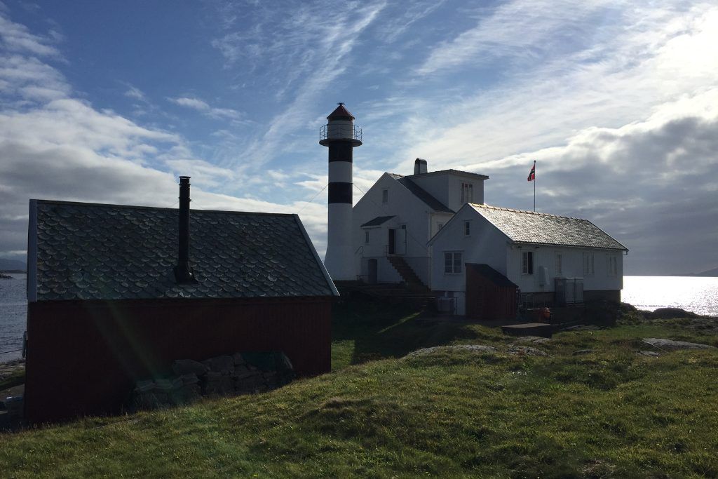 A view of the private lighthouse in Norway with additional surrounding buildings.