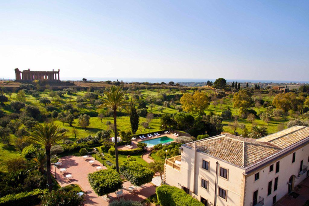 The exterior of the Villa Athena with a pool and sprawling garden.
