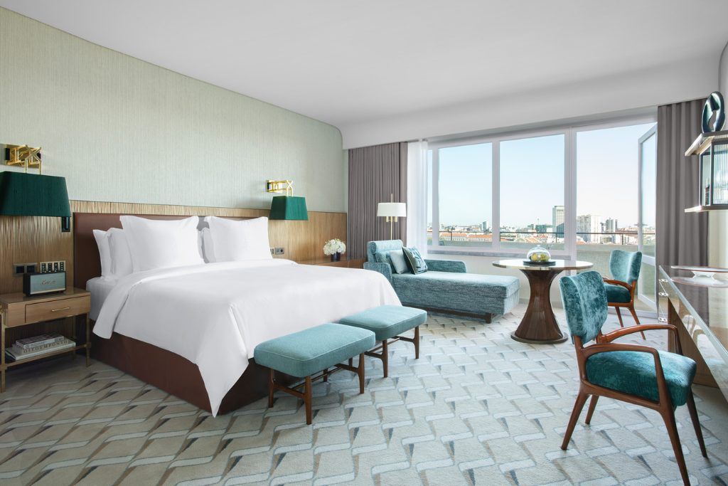 A spacious bedroom with city views in the Four Seasons Ritz Hotel in Lisbon.