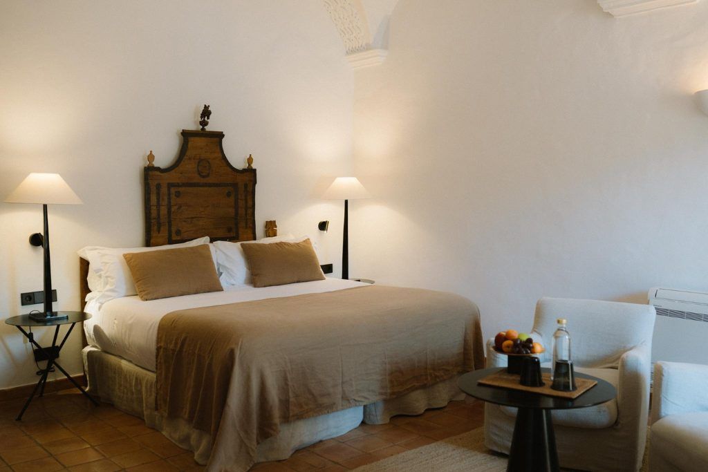 The simple white-washed room with a wooden headboard in Mas de Torrent.