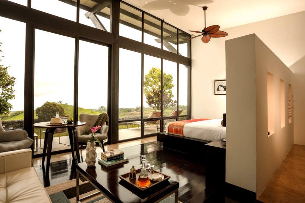 A room with large windows looking out over the Galapagos Islands at Pikaia Lodge.