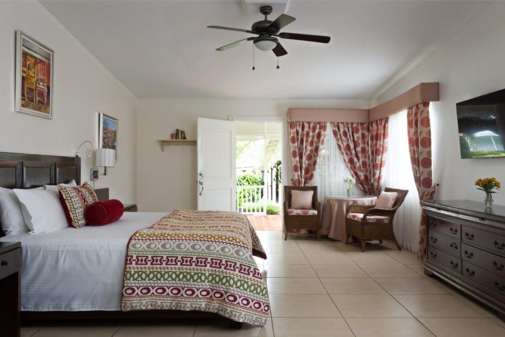 One of the rooms at Hotel Panamonte with colorful curtains and two chairs in teh corner.