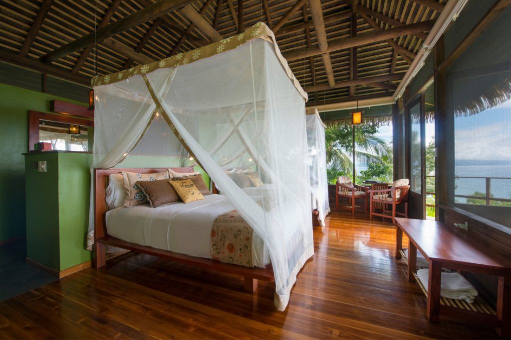 A private bungalow with a canopy-covered bed at the Lapa Rios Ecolodge.