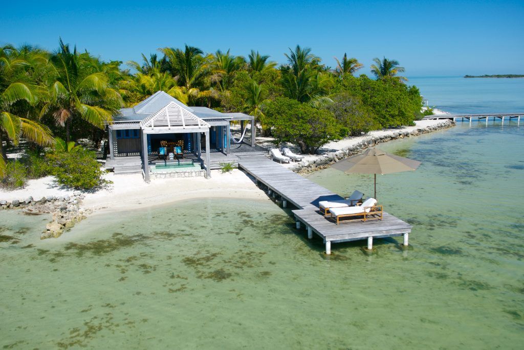 A beachfront pier with loungers on it at Cayo Espanto.