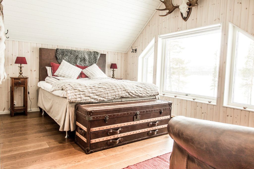 A simple bedroom with Scandinavian decor and rustic accents at Fejllborg Arctic Lodge.