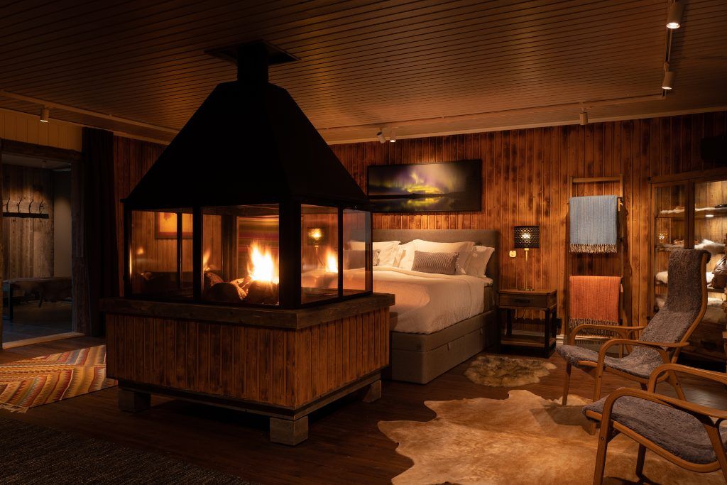 The bed and fireplace inside the Logger's Lodge in Swedish Lapland.