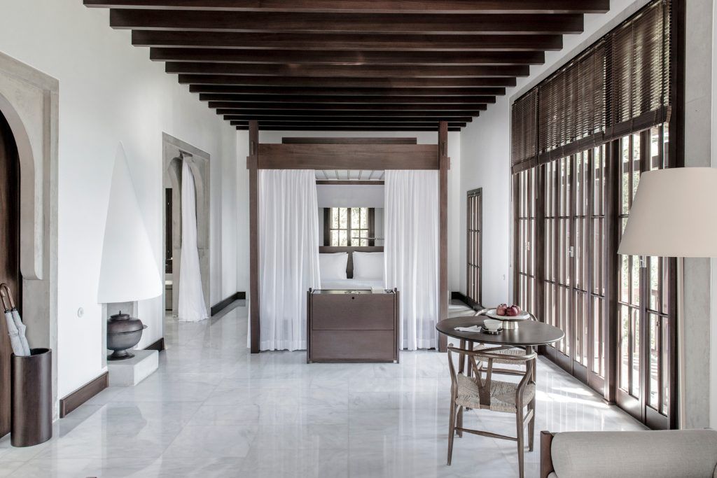 A four poster bed with a light canopy around it in one of the rooms at Amanruya.