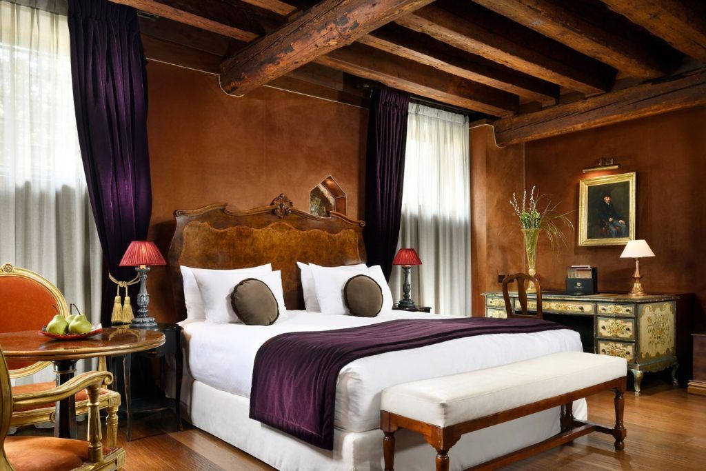 A bedroom with wooden walls and wood beam ceilings in the Palazzo Venart.