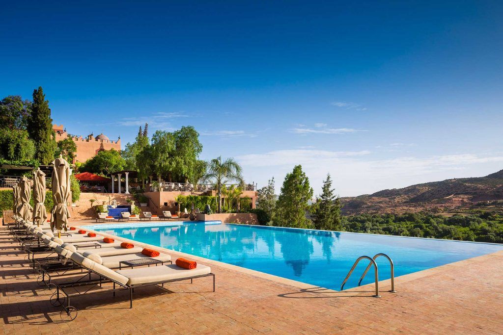 An outdoor swimming pool on a sunny day at Kasbah Tamadot.