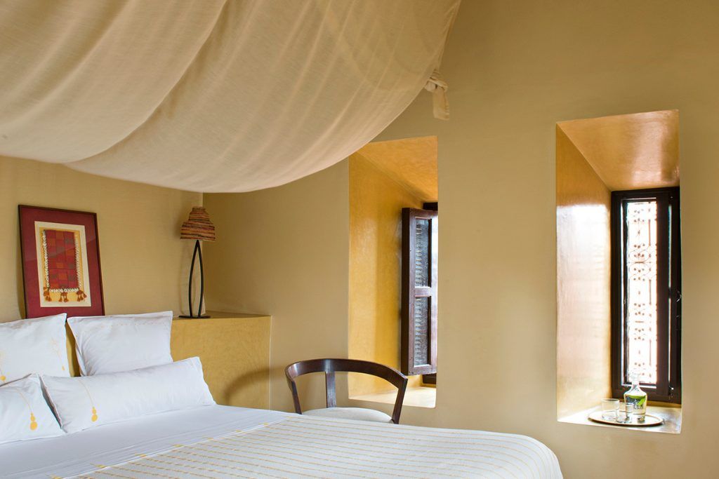 A bedroom with two windows at Dar Ahlam.