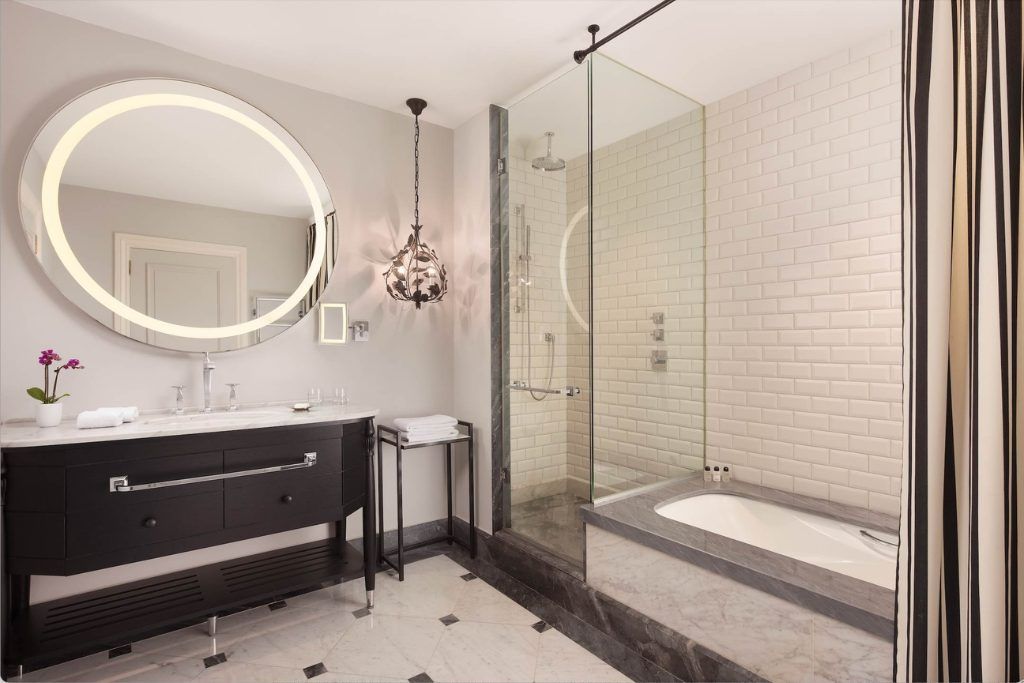 A modern bathroom with a glass-walled shower and tub at Hotel Maria Cristina.