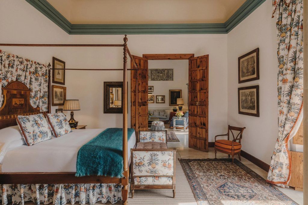 The four poster bed with a blue throw on it at Grand Hotel Son Net.