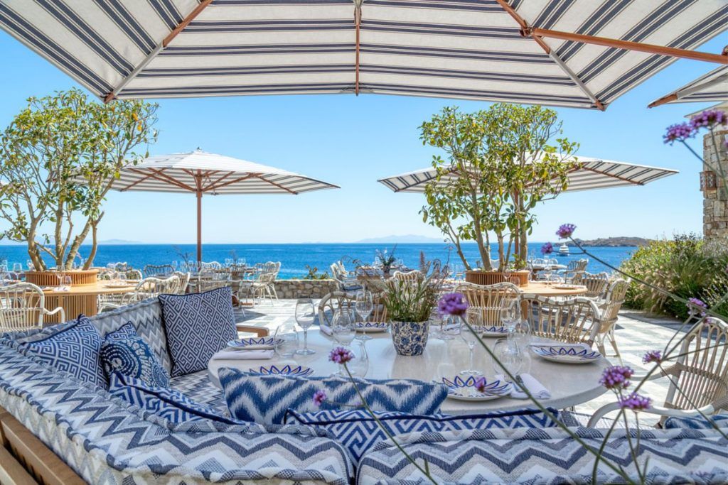 A patio area with loungers and plants at the Santa Marina hotel in Mykonos.