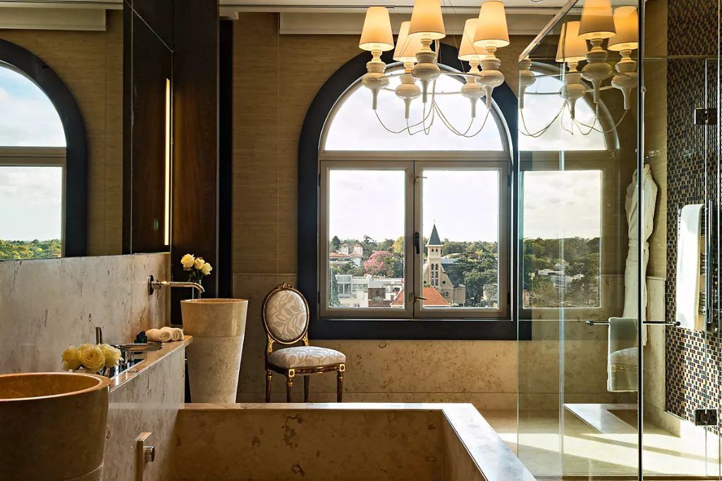 A luxury bathroom at the Sofitel Montevideo with a large window looking over the city.