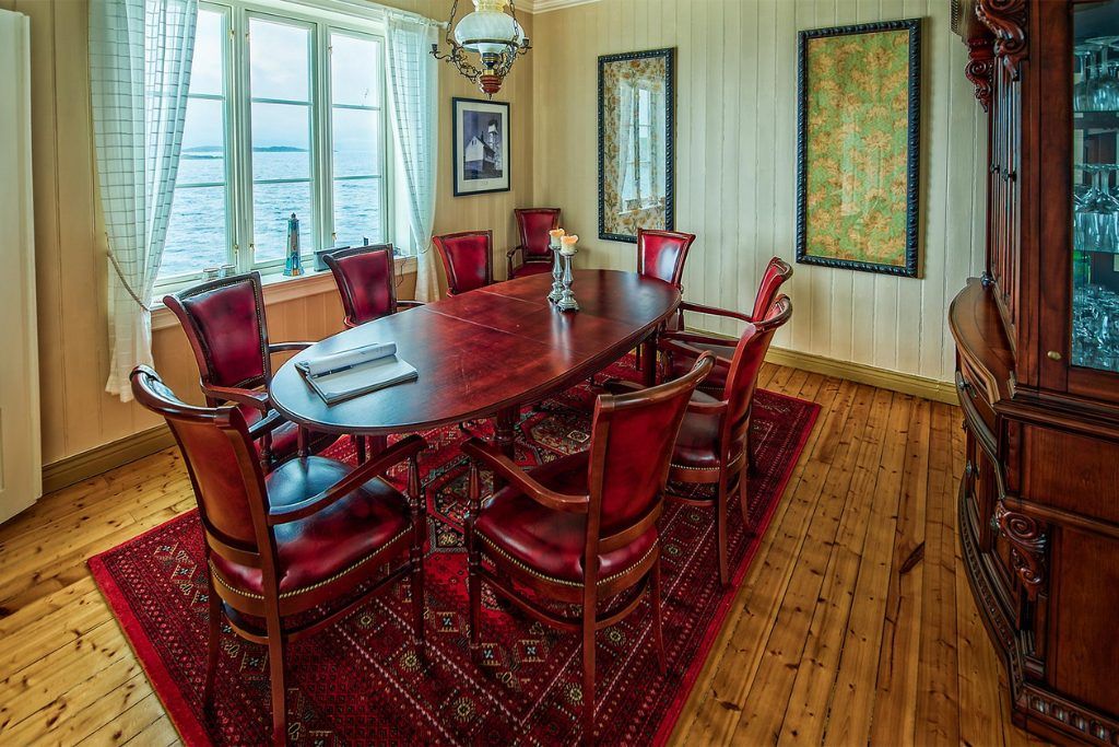A dining room with a wooden table and chairs in a private lighthouse.