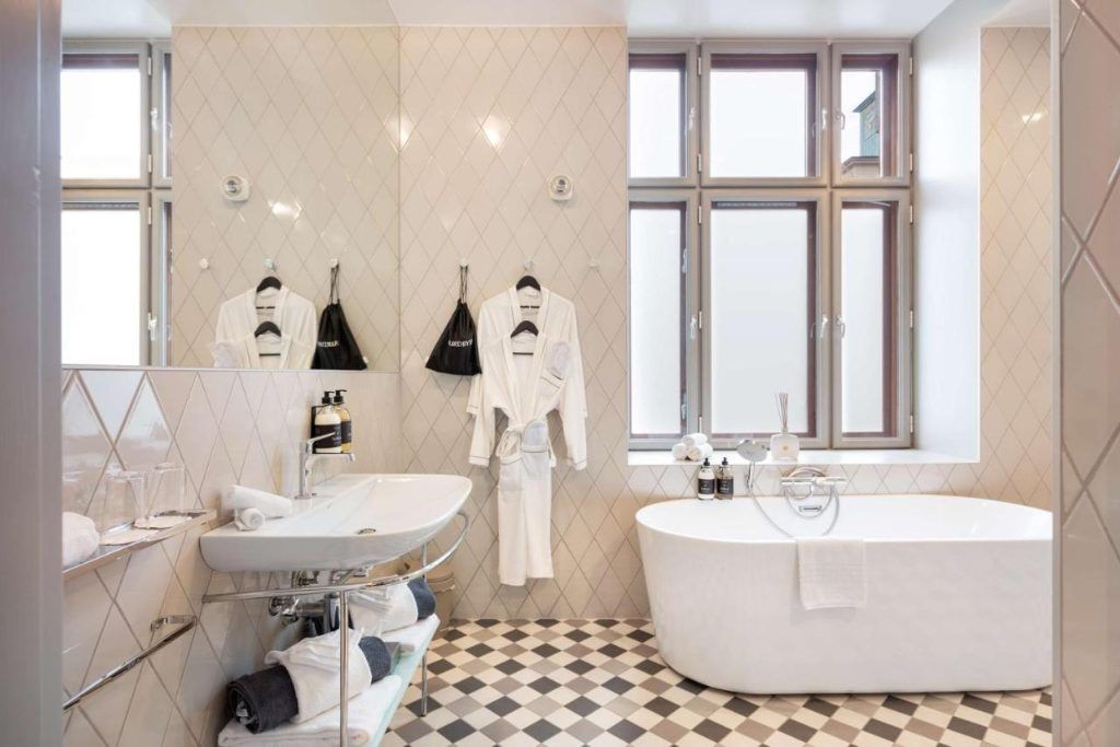 A sunny bathroom with a robe hanging on a hook in the Bergen Børs hotel.