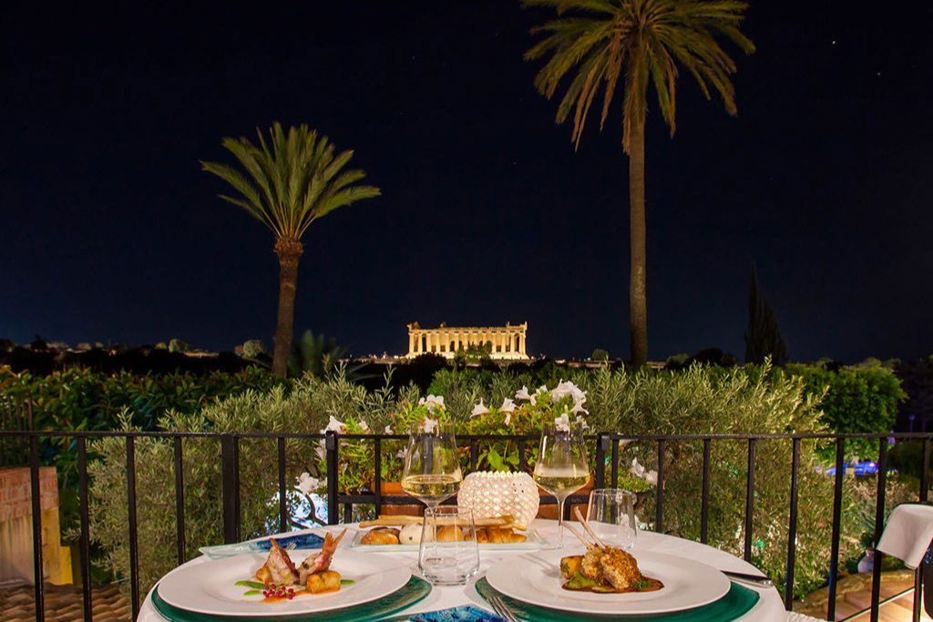 The outdoor restaurant at Villa Athena with views of an old temple.