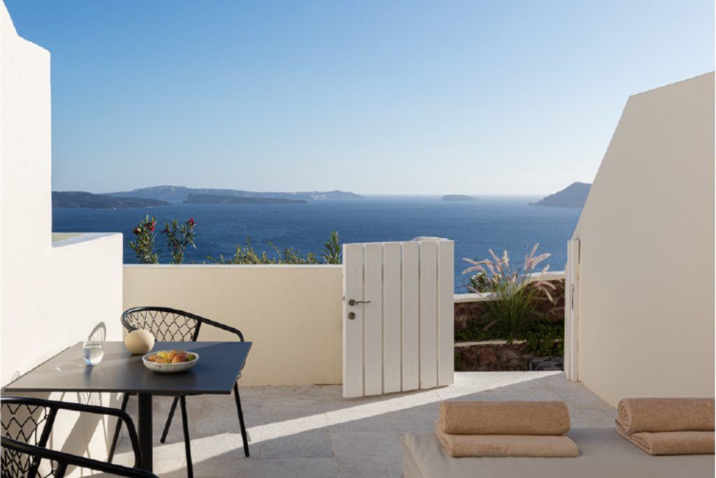 An outdoor area with a gate and a view of the bay at Canavas Oia Suites.