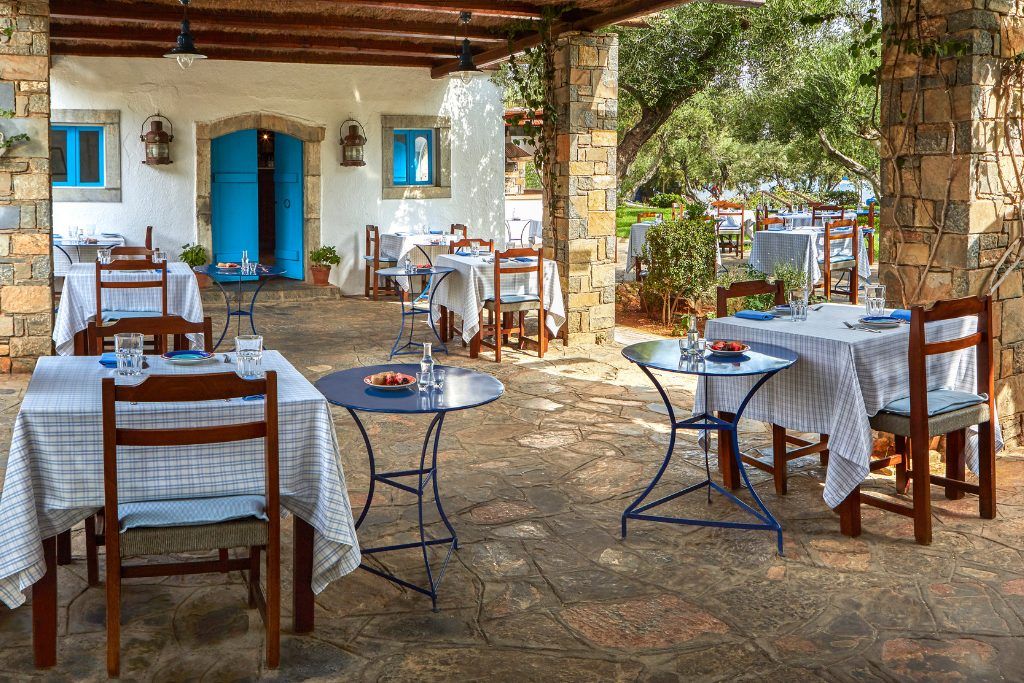 An outdoor restaurant on a stone patio at Elounda Beach Hotel