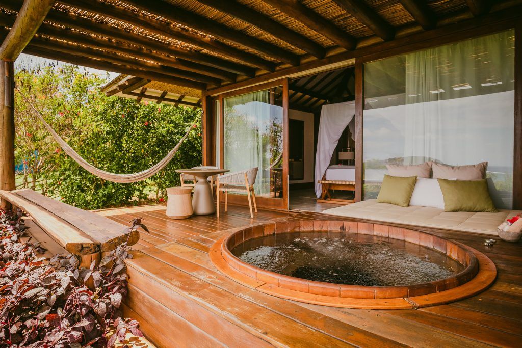 A view of the deck of a bungalow at Pousada Maravilha, with a jacuzzi and a hammock.