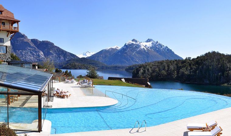 The swimming pool at the Llao Llao resort with mountains in the background.