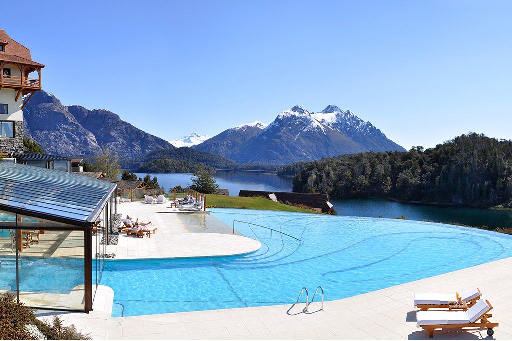 The swimming pool at the Llao Llao resort with mountains in the background.