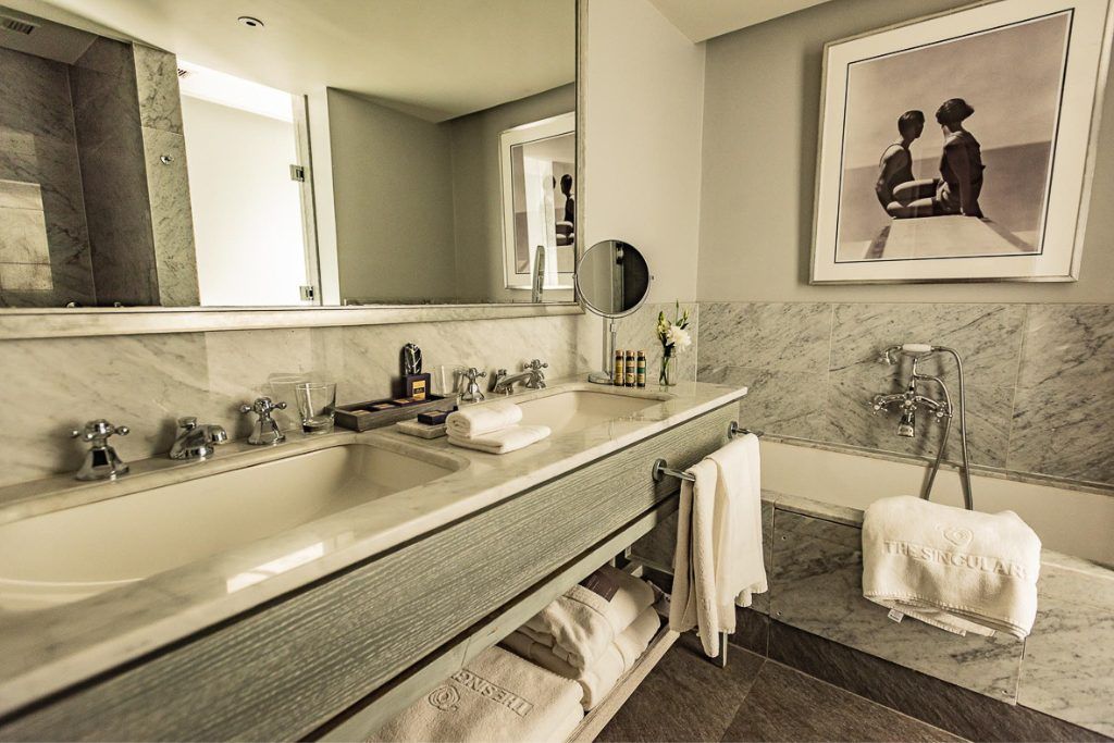 A modern bathroom with a tub and large sink at the Singular Santiago.