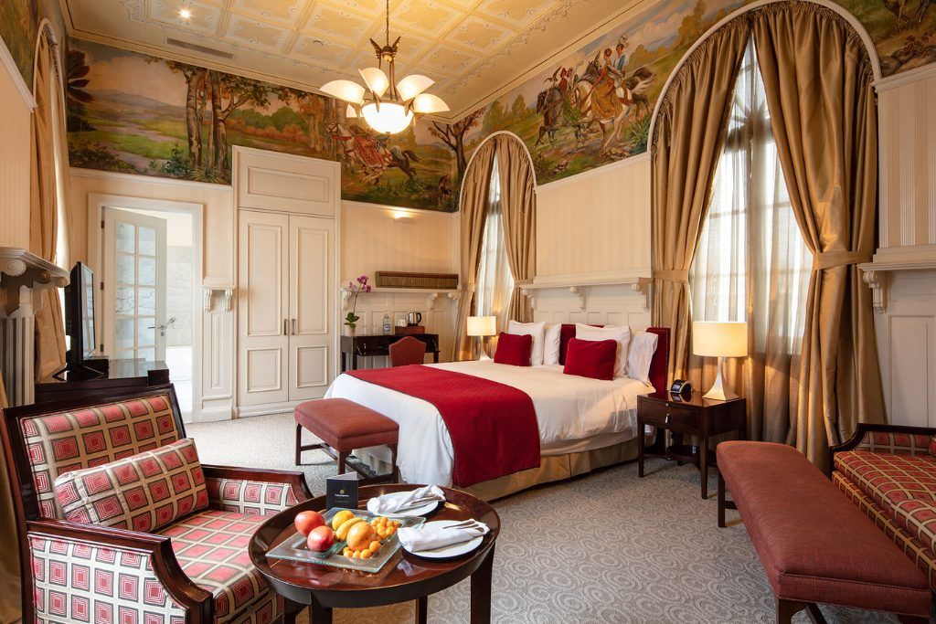 One of the luxurious rooms at Casa Gangotena with a table with fruit on it in the corner.